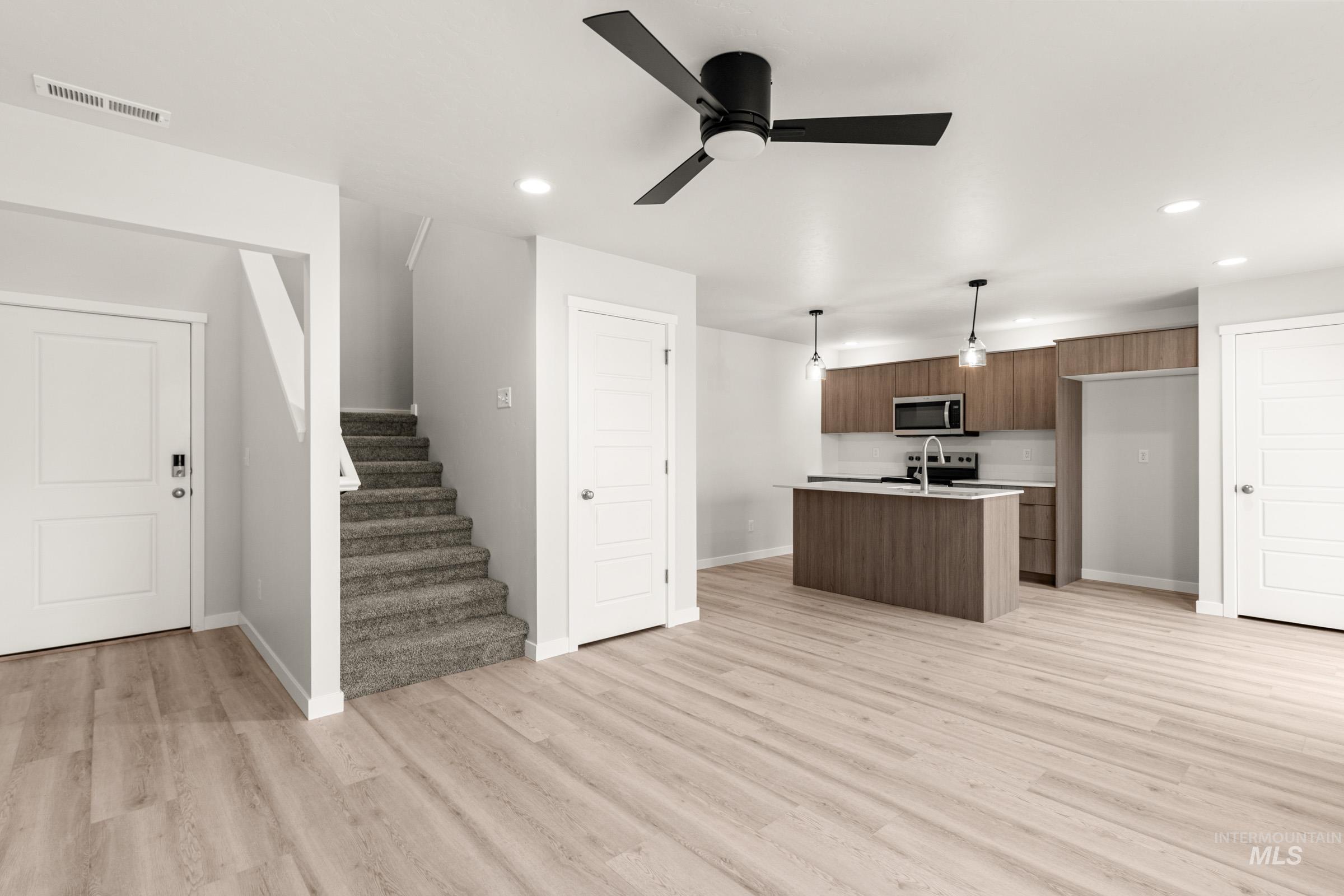 10830 Rutland Street Caldwell, ID 83605 - Photo 21 of 21 Kitchen featuring decorative light fixtures, a center island with sink, open floor plan, stainless steel appliances, and a ceiling fan