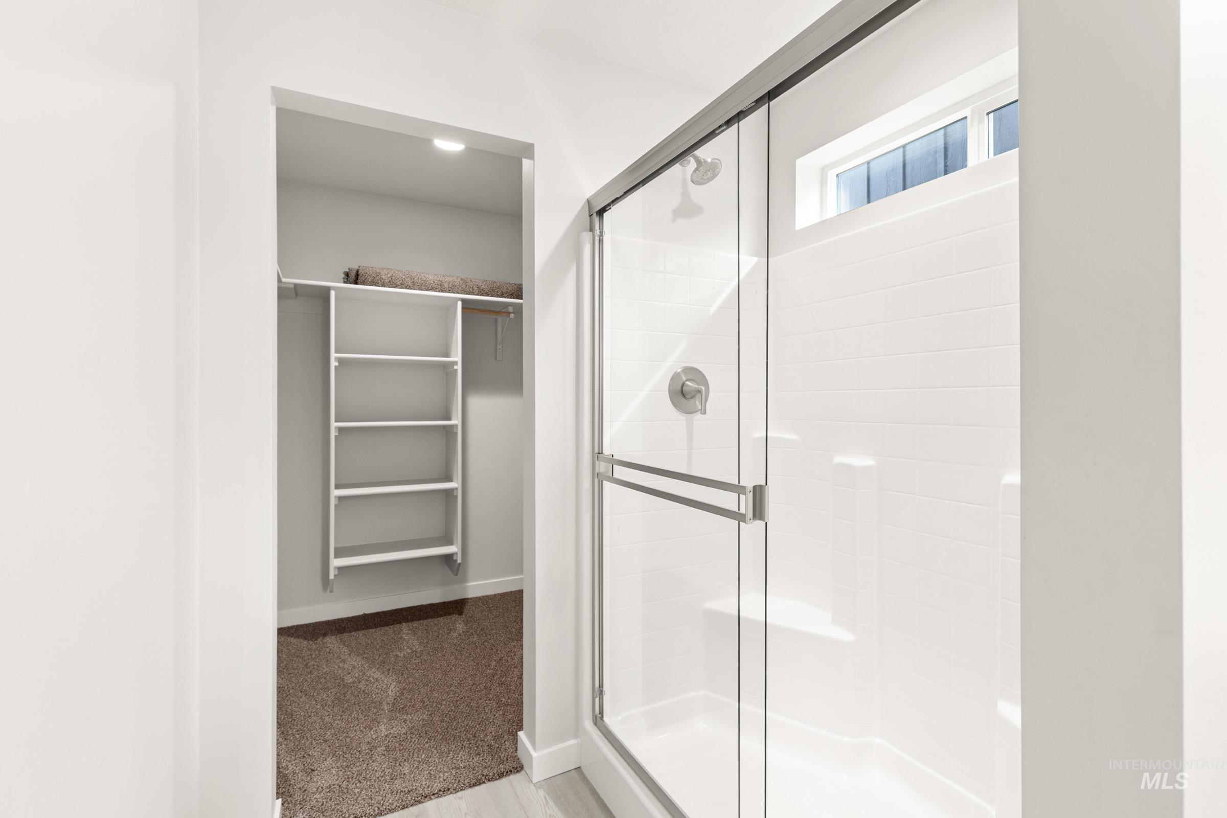 10830 Rutland Street Caldwell, ID 83605 - Photo 16 of 21 Bathroom with a stall shower, a walk in closet, and light colored carpet