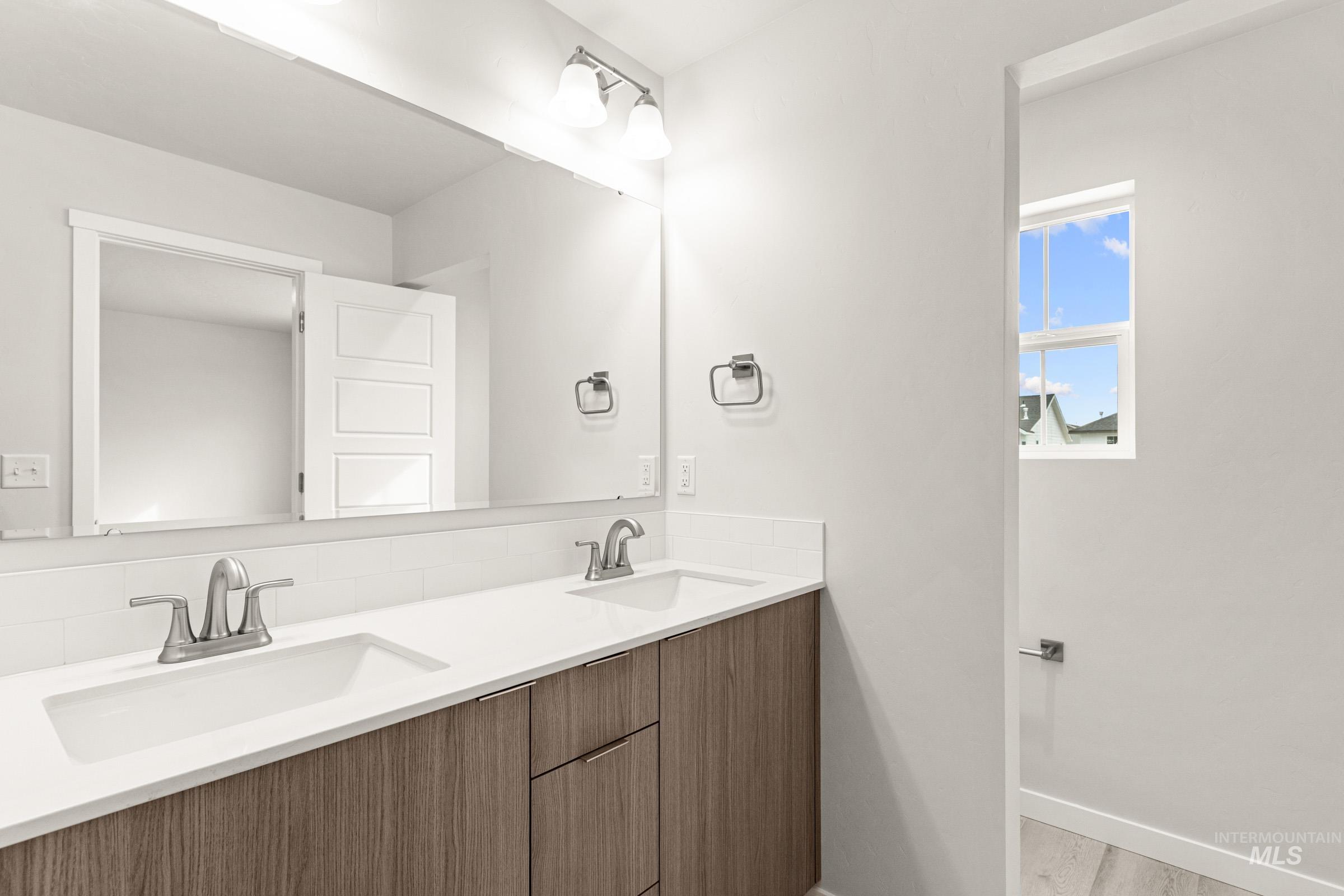 10830 Rutland Street Caldwell, ID 83605 - Photo 18 of 21 Bathroom with double vanity and light wood-style floors