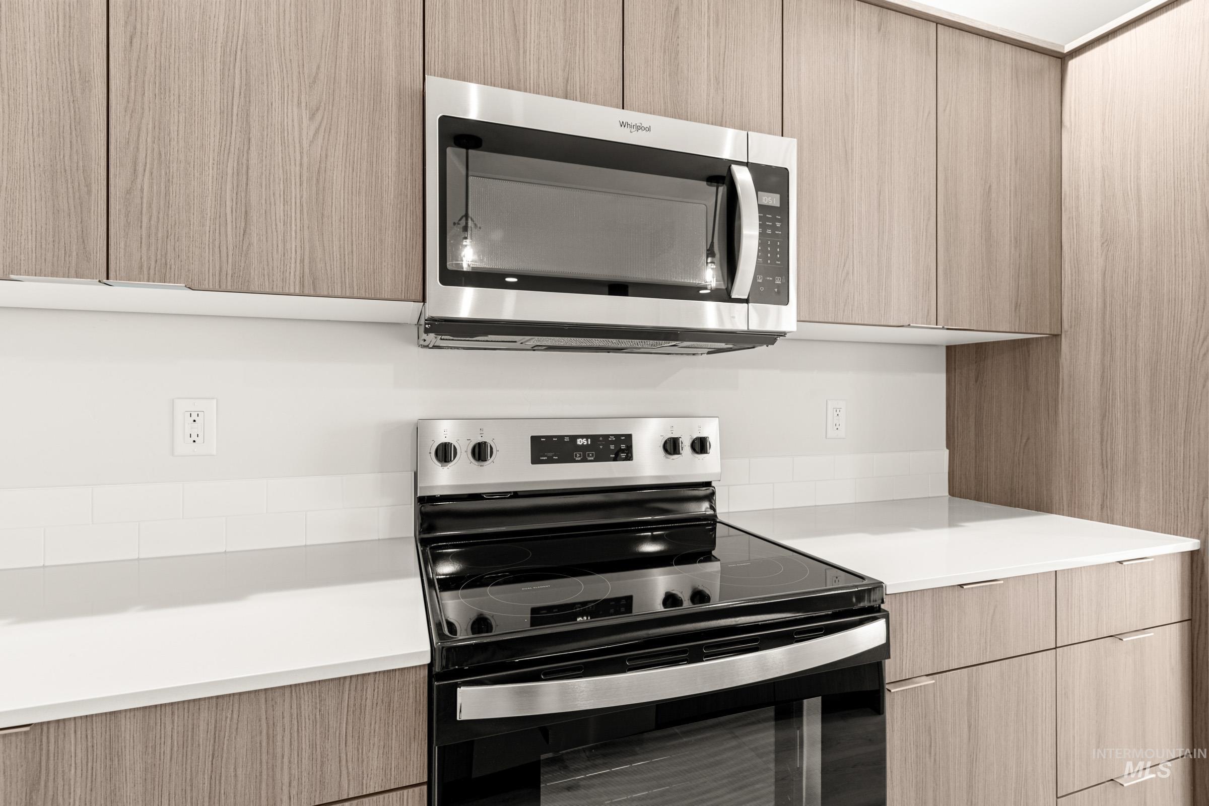 10830 Rutland Street Caldwell, ID 83605 - Photo 6 of 21 Kitchen featuring range with electric cooktop, modern cabinets, stainless steel microwave, and light wood finish cabinetry