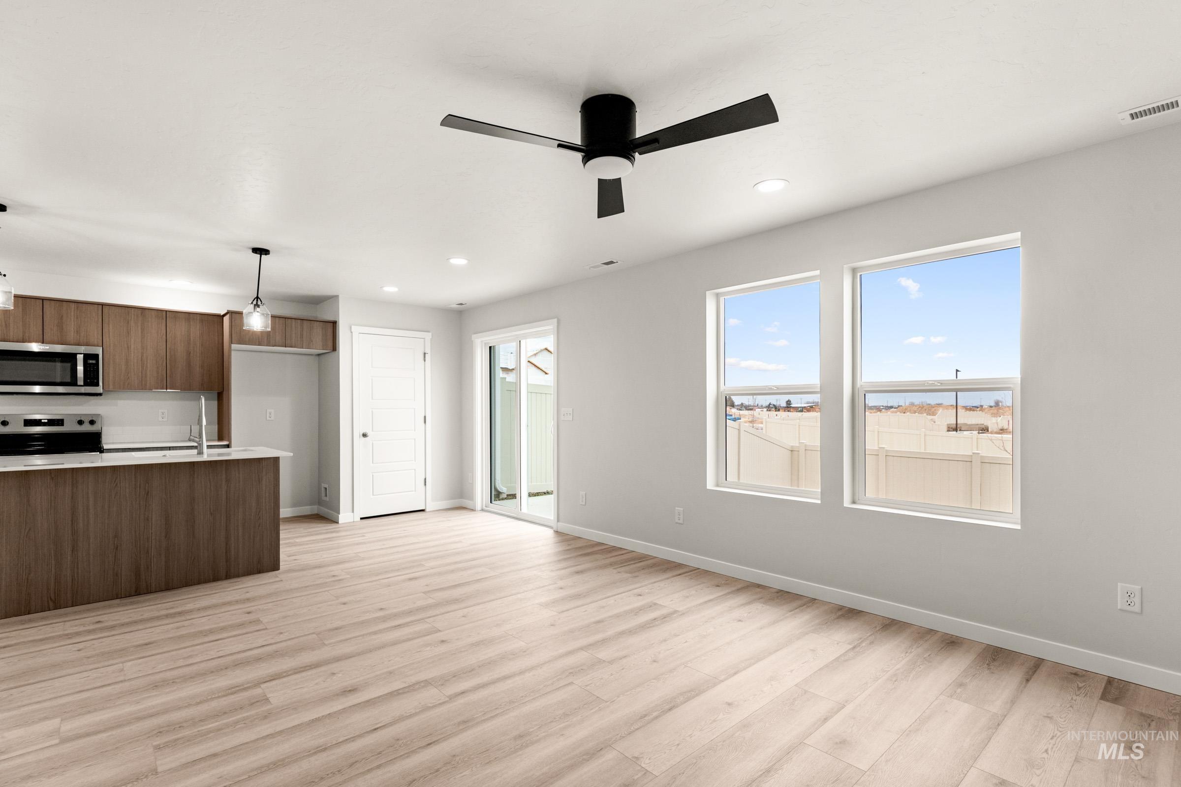 10830 Rutland Street Caldwell, ID 83605 - Photo 9 of 21 Kitchen featuring modern cabinets, stainless steel appliances, light wood-type flooring, hanging light fixtures, and ceiling fan