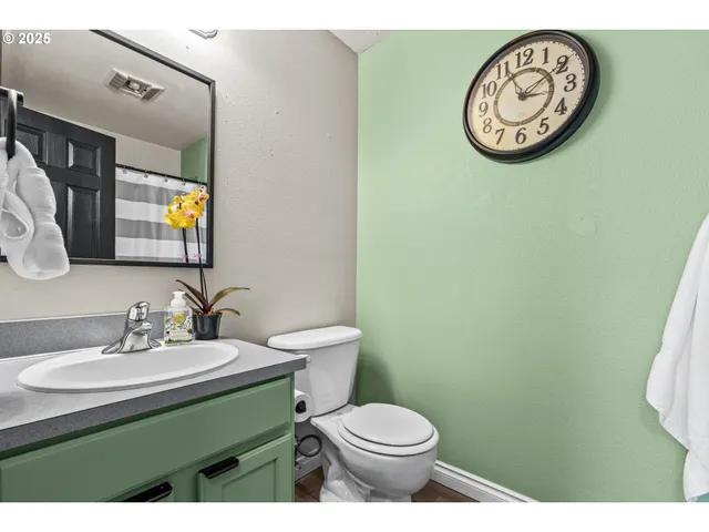 a bathroom with a sink a toilet a mirror and shower curtain