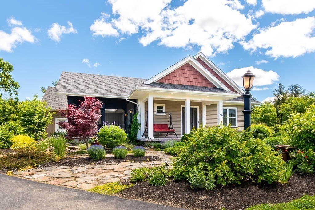 a front view of a house with a yard and a garden