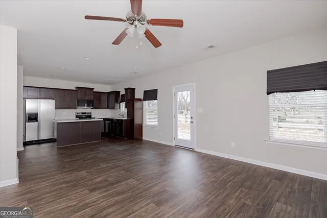 a kitchen with stainless steel appliances granite countertop a stove a refrigerator and a sink with wooden cabinets