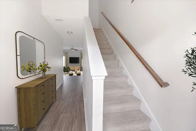 a view of a hallway with wooden floor and staircase