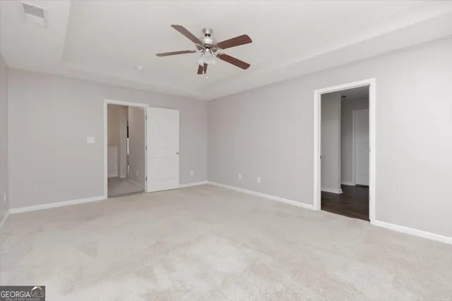 an empty room with a ceiling fan and a window
