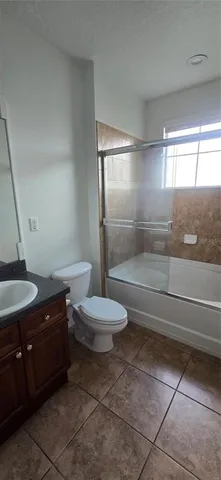 a bathroom with a granite countertop sink a toilet a vanity and shower