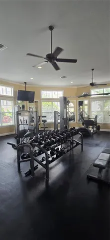 a gym room with lots of furniture and a chandelier