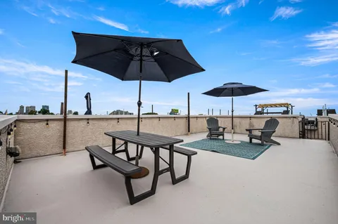 a view of a patio with a table and chairs under an umbrella