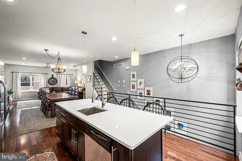a kitchen with stainless steel appliances a table chairs refrigerator and cabinets