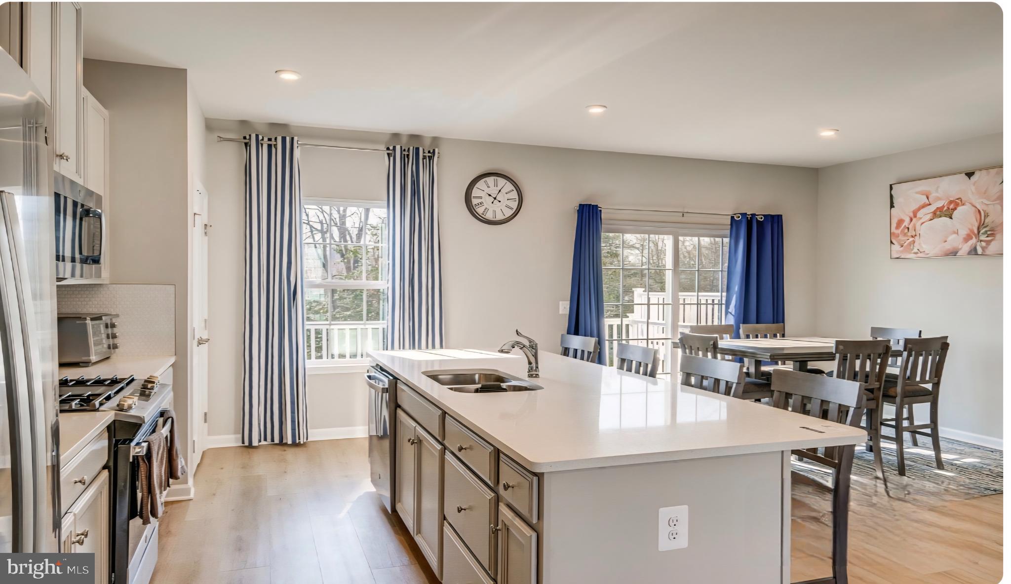 14489 Dolce Lane Woodbridge, VA 22193 - Photo 6 of 26 a kitchen with stainless steel appliances a table and chairs in it