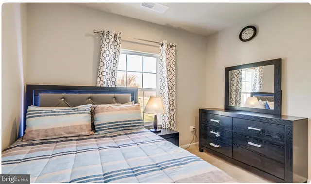 a spacious bedroom with a bed and a dresser