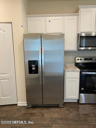 a kitchen with a refrigerator and a stove