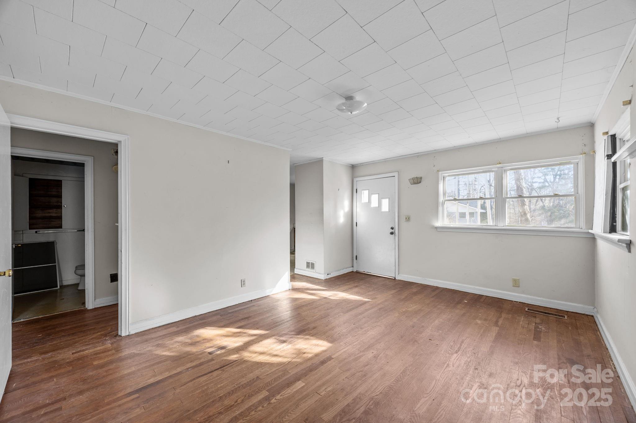 228 Grove Street Brevard, NC 28712 - Photo 12 of 44 an empty room with wooden floor and windows