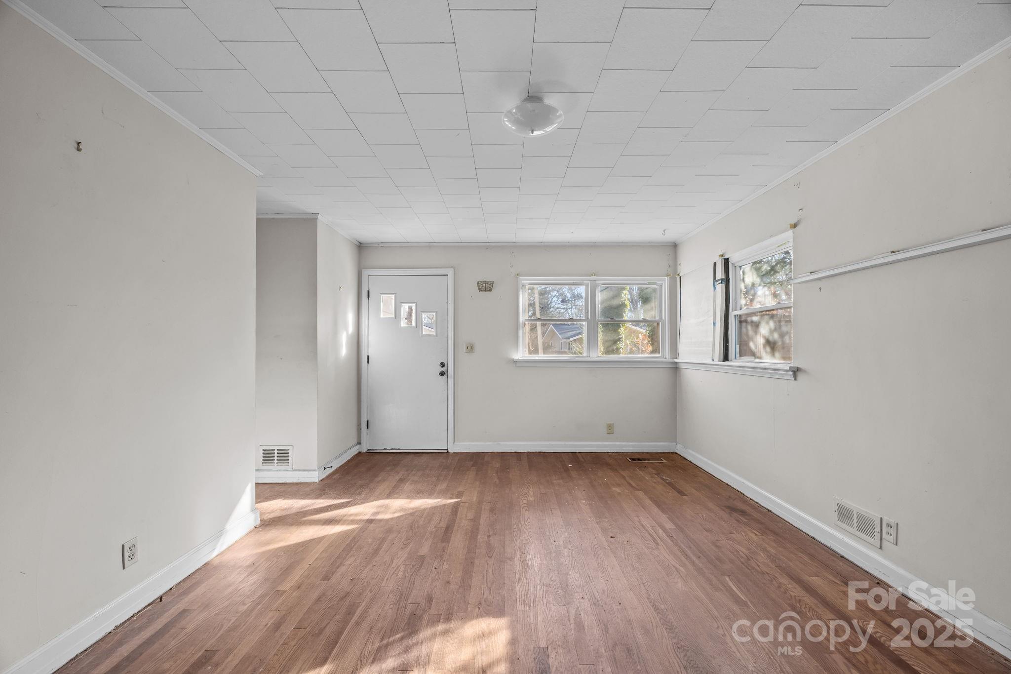 228 Grove Street Brevard, NC 28712 - Photo 13 of 44 an empty room with wooden floor and windows
