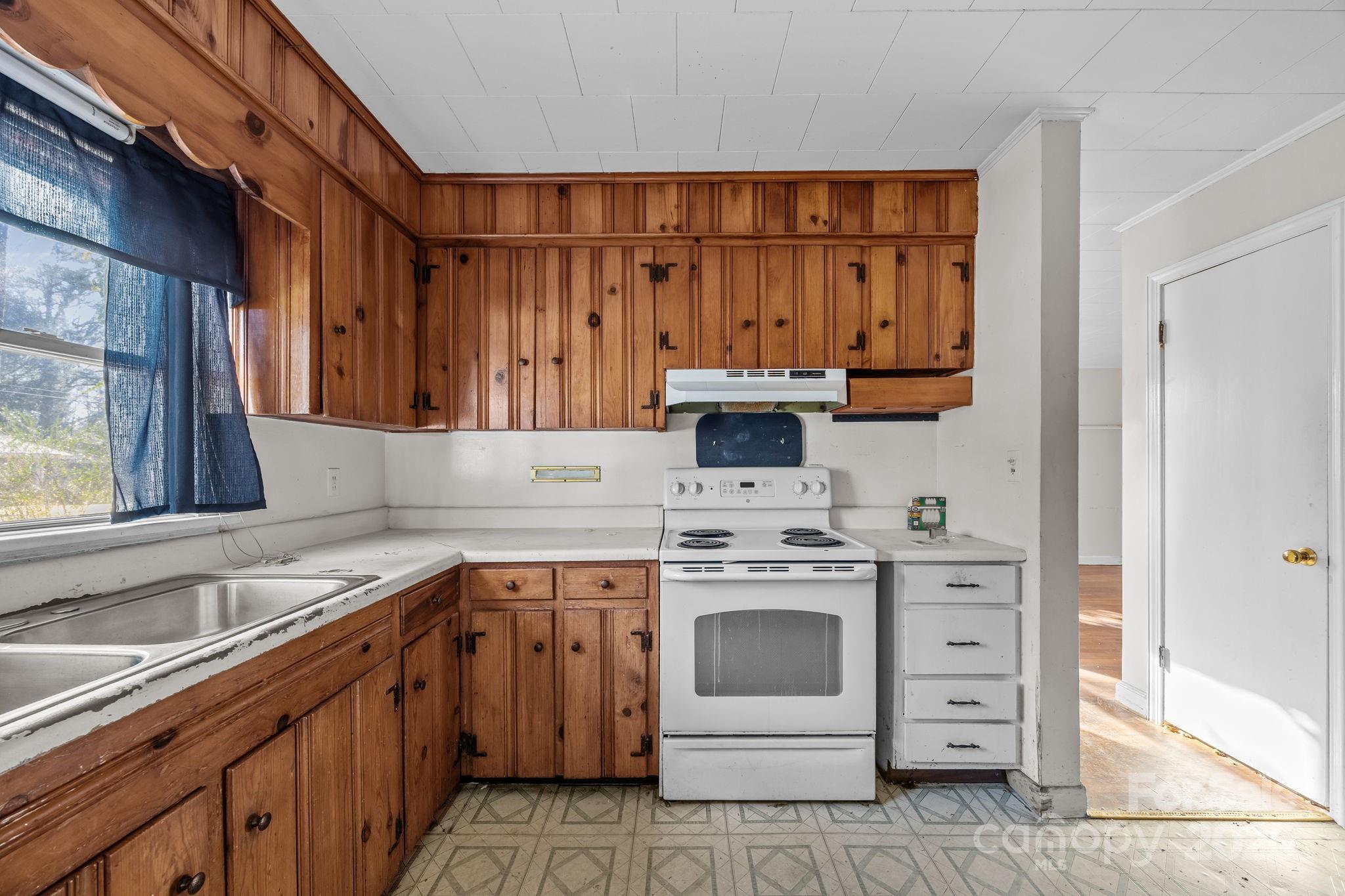 228 Grove Street Brevard, NC 28712 - Photo 18 of 44 a kitchen with a stove sink and cabinets