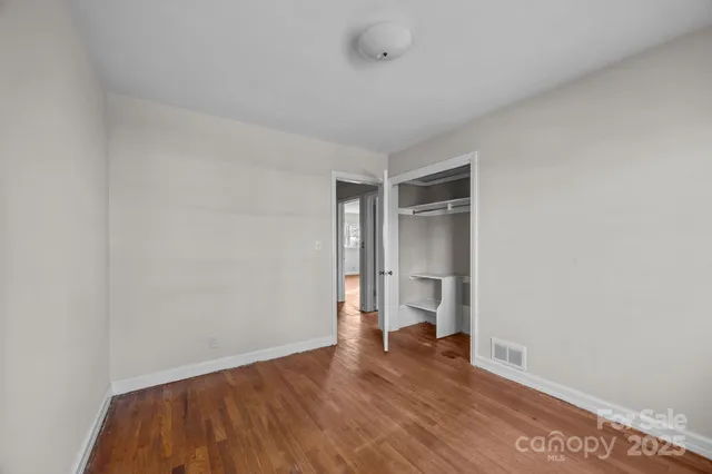 a view of empty room with wooden floor and cabinet