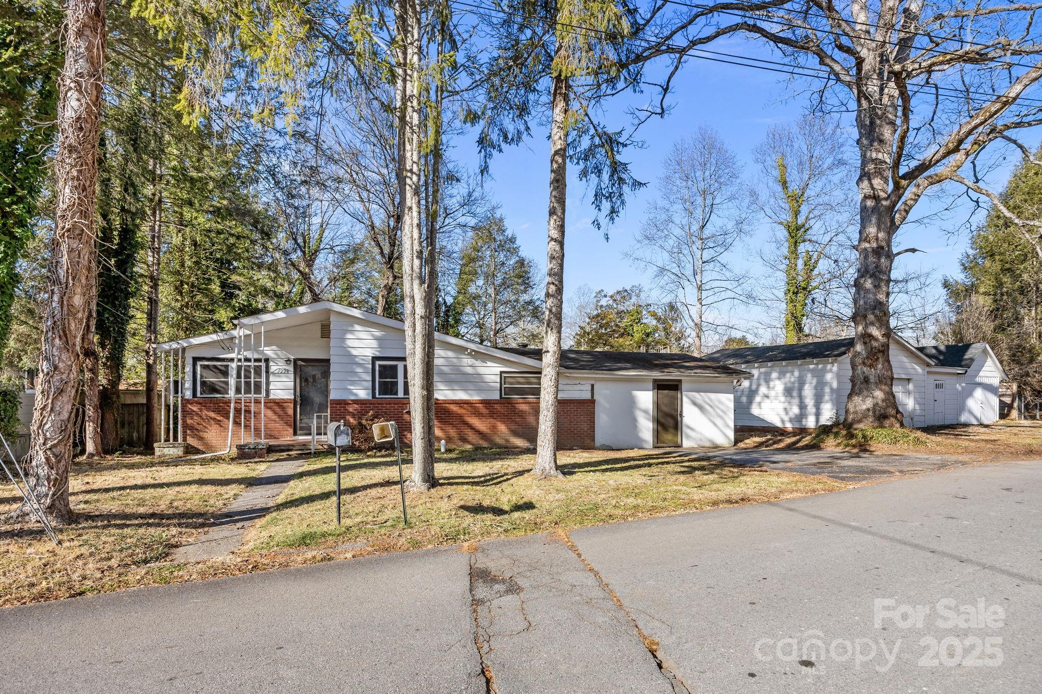 228 Grove Street Brevard, NC 28712 - Photo 7 of 44 a view of a house with large tree and wooden fence