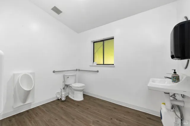 a view of an empty room with kitchen and a sink