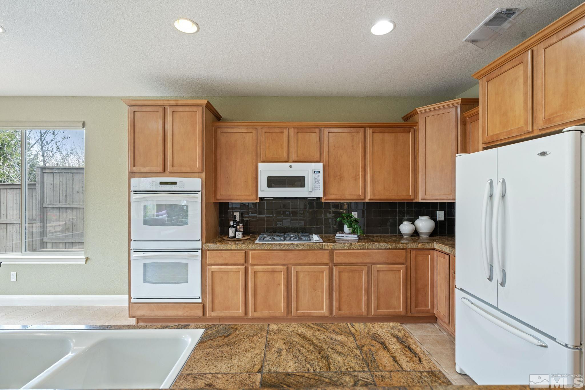 610 Aberdeen Court Reno, NV 89521 - Photo 8 of 40 a kitchen with stainless steel appliances granite countertop a refrigerator sink and cabinets