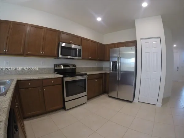 a kitchen with stainless steel appliances granite countertop a refrigerator and a stove top oven