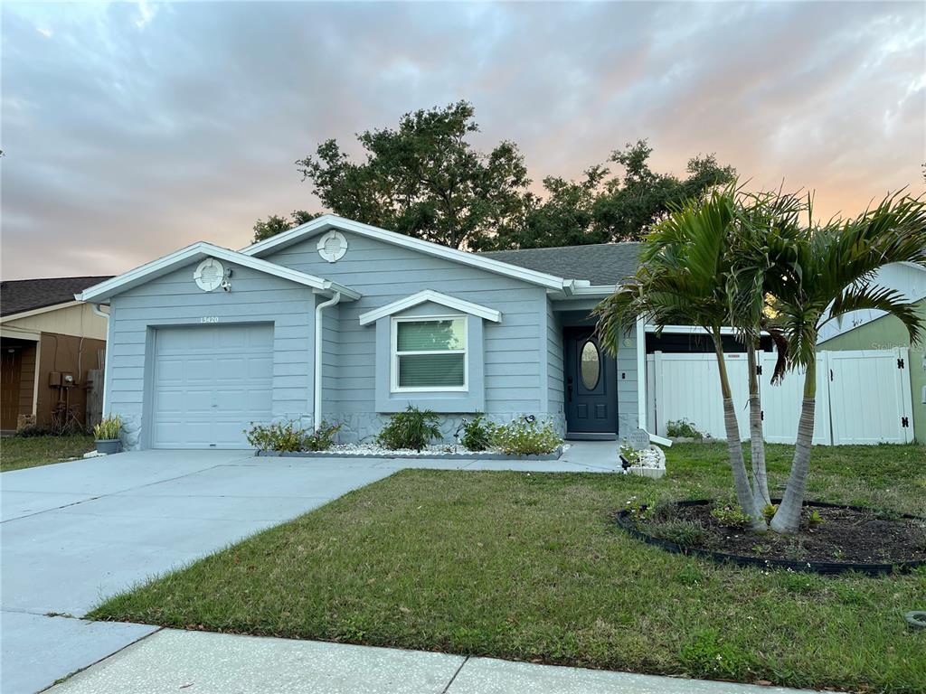 a front view of a house with a yard and potted plants