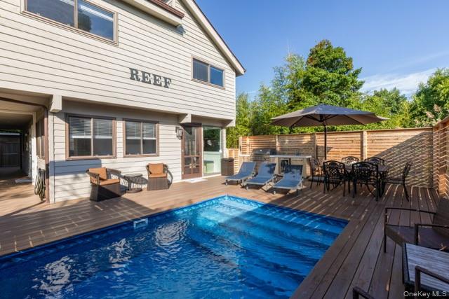 a view of a patio with table and chairs under an umbrella with wooden floor