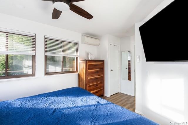 294 Wilmot Road Ocean Beach, NY 11770 - Photo 14 of 38 a bedroom with a bed and wooden floor