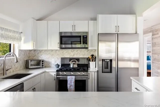 a kitchen with cabinets stainless steel appliances and a counter space