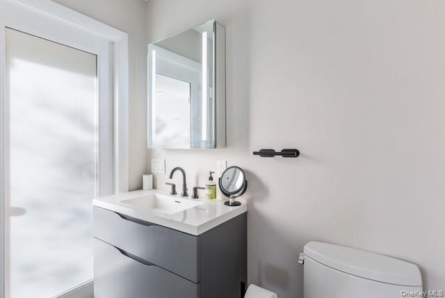 294 Wilmot Road Ocean Beach, NY 11770 - Photo 24 of 38 a bathroom with a sink a toilet and mirror