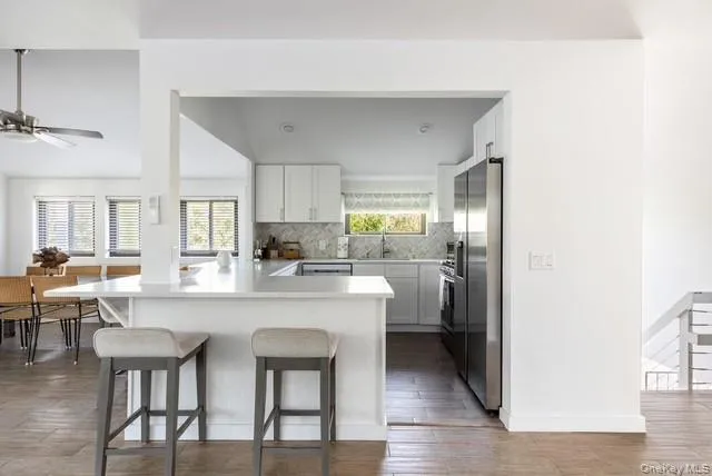 a kitchen with a dining table chairs cabinets and stainless steel appliances