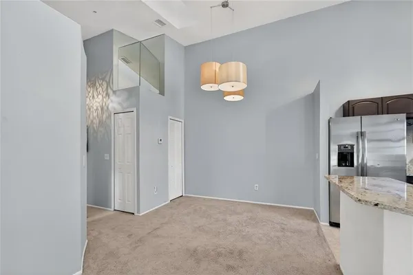 a view of an empty room with a chandelier fan