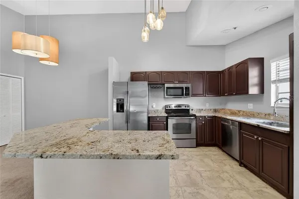 a kitchen with stainless steel appliances granite countertop wooden cabinets a stove a sink and dishwasher