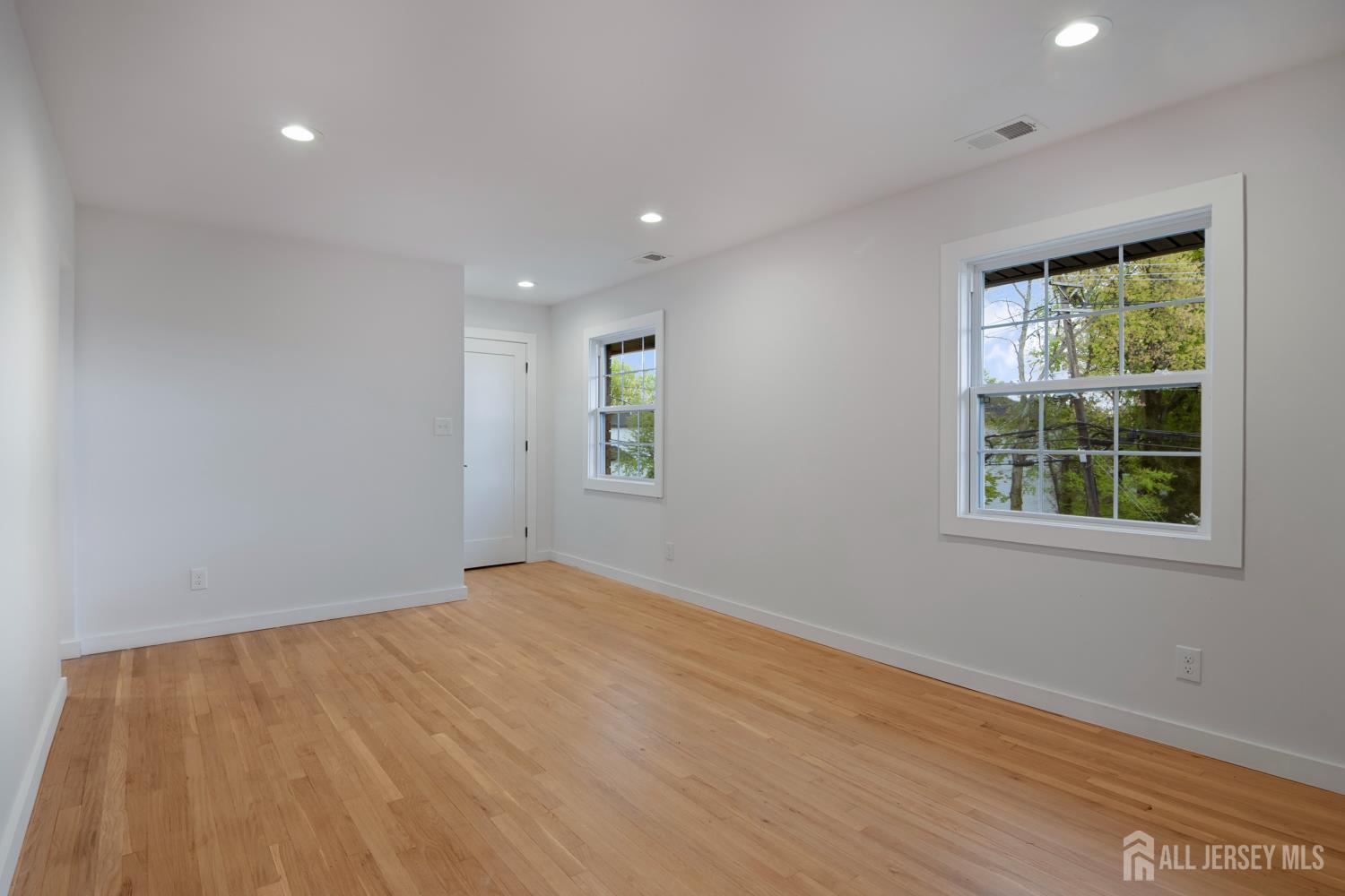 4 Morris Avenue, Unit 2A Edison, NJ 08837 - Photo 9 of 27 a view of an empty room with wooden floor and a window