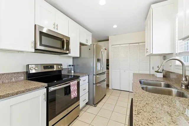 a kitchen with stainless steel appliances granite countertop a refrigerator stove microwave and sink