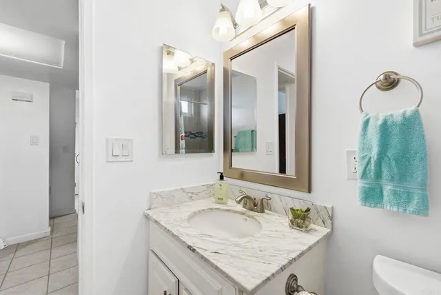 a bathroom with a granite countertop sink and a mirror