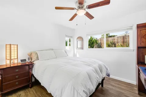 a bedroom with a bed and wooden floor