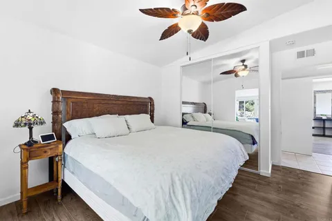 a bedroom with bed and wooden floor