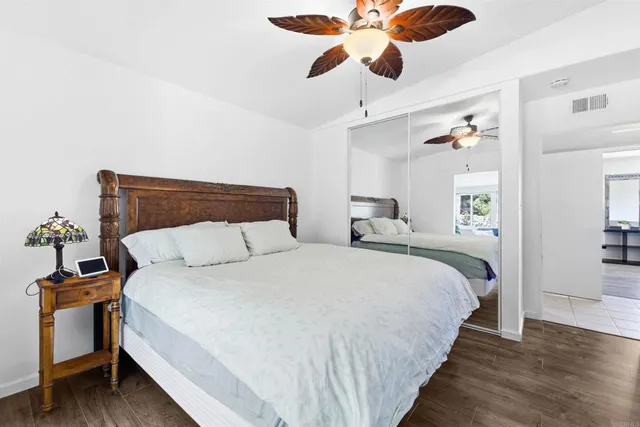 a bedroom with bed and wooden floor