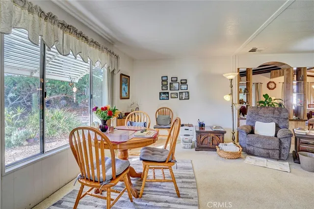 a dining room with furniture and a large window