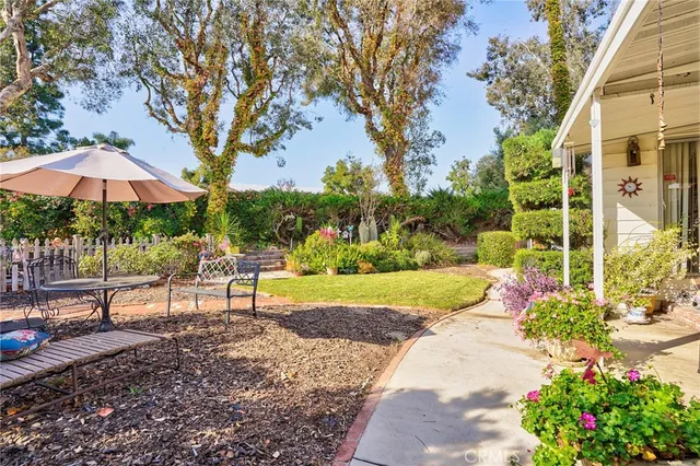a view of a house with a big yard and large trees