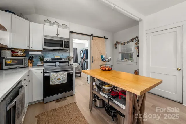 a kitchen with stainless steel appliances a stove a sink and a refrigerator
