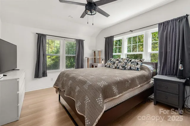 a large bed sitting in a bedroom next to a window with a flat screen tv