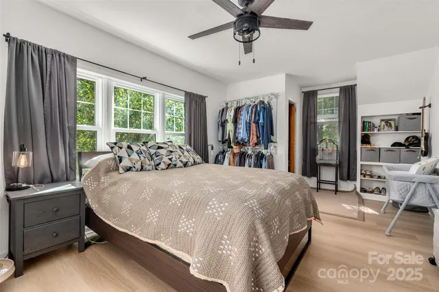 a bed sitting in a spacious bedroom next to a window