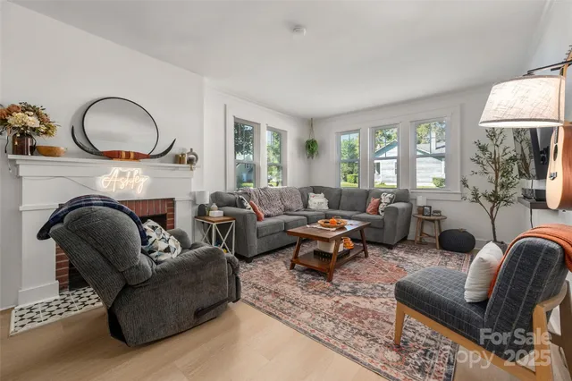 a living room with furniture fireplace and a large window