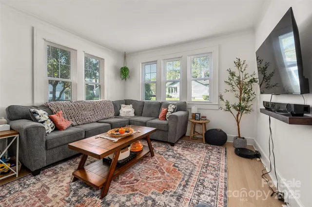 a living room with furniture a flat screen tv and a window