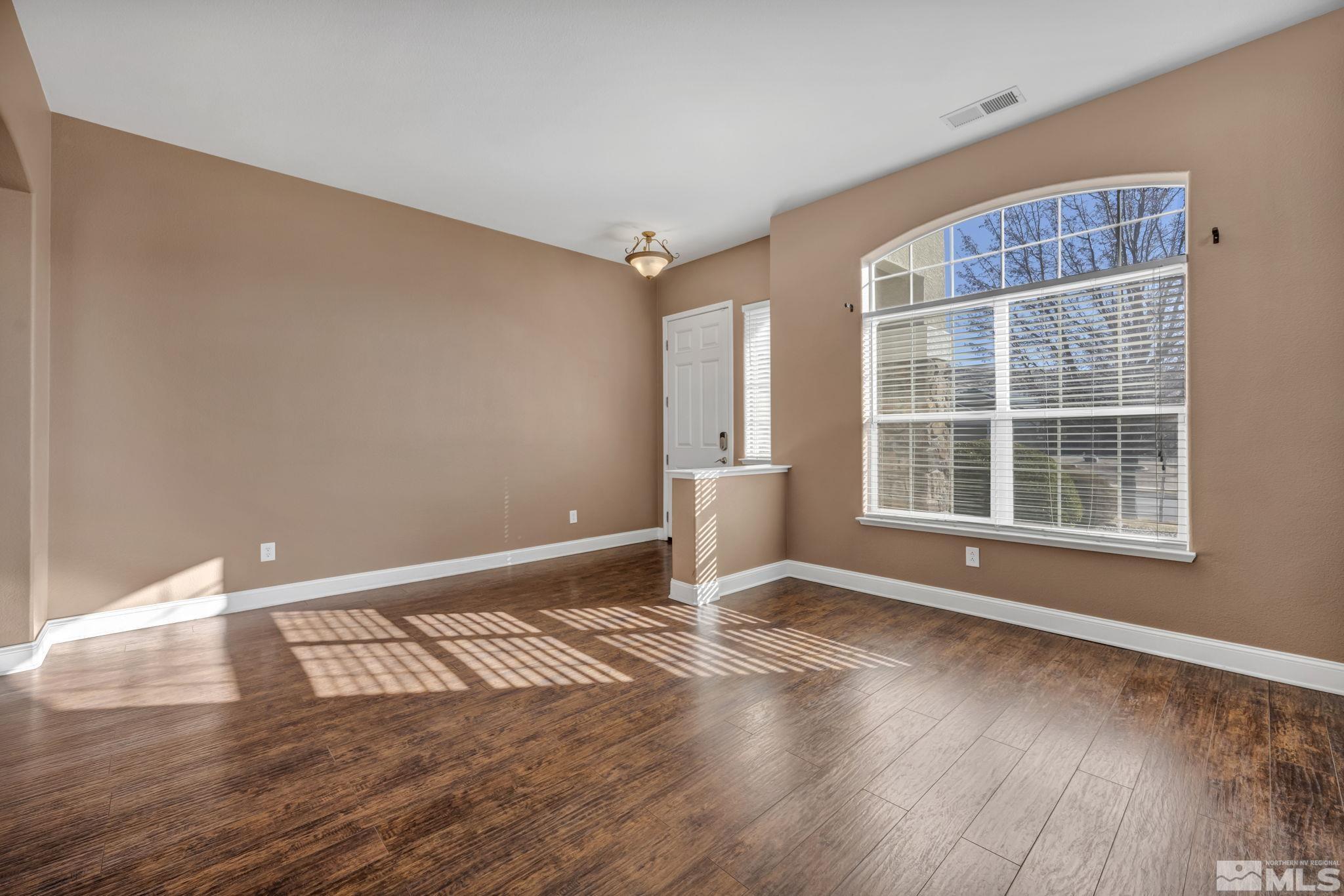 7301 Lacerta Drive Sparks, NV 89436 - Photo 12 of 39 a view of an empty room with wooden floor and a window