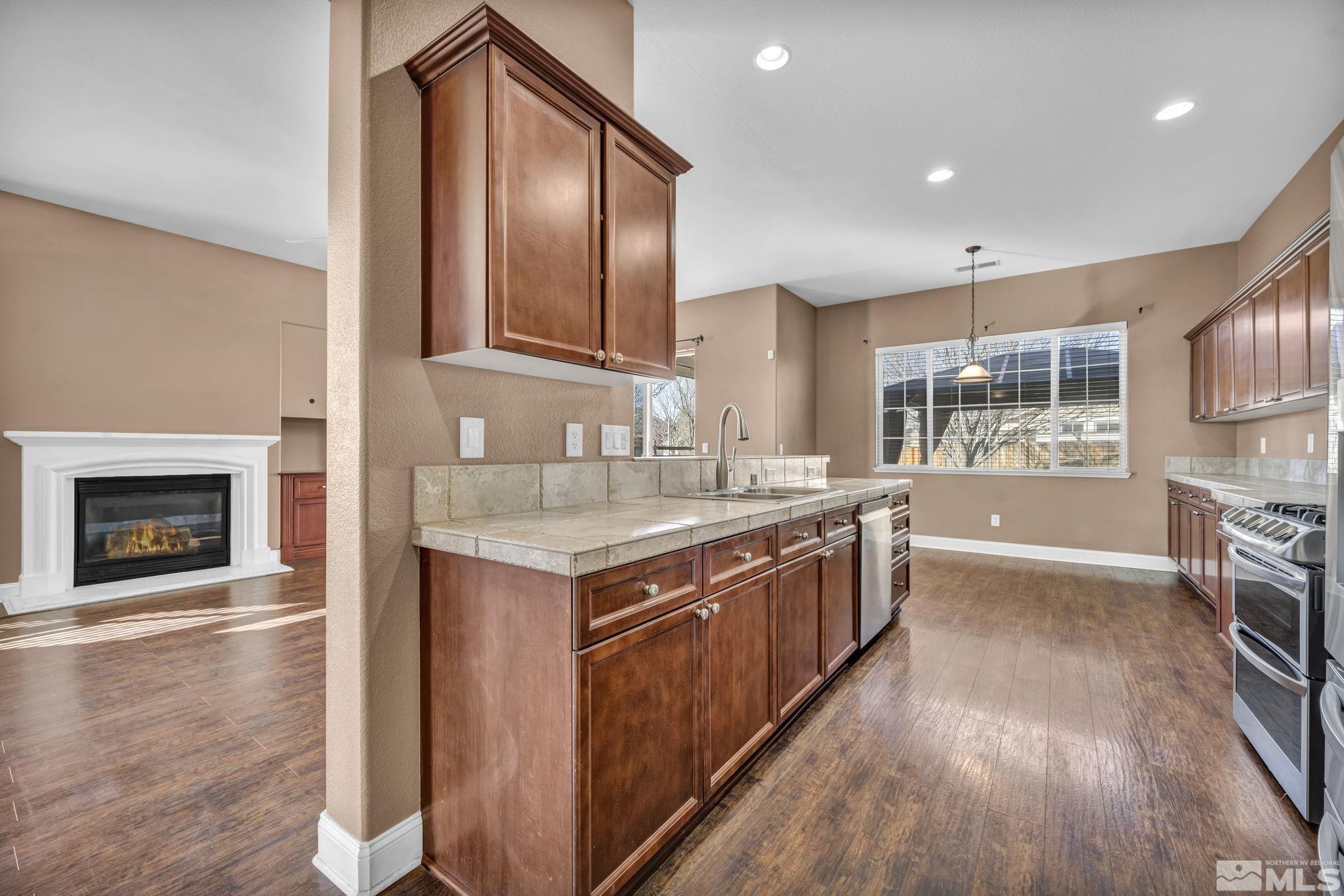 7301 Lacerta Drive Sparks, NV 89436 - Photo 21 of 39 a kitchen with stainless steel appliances granite countertop a stove a sink and a refrigerator