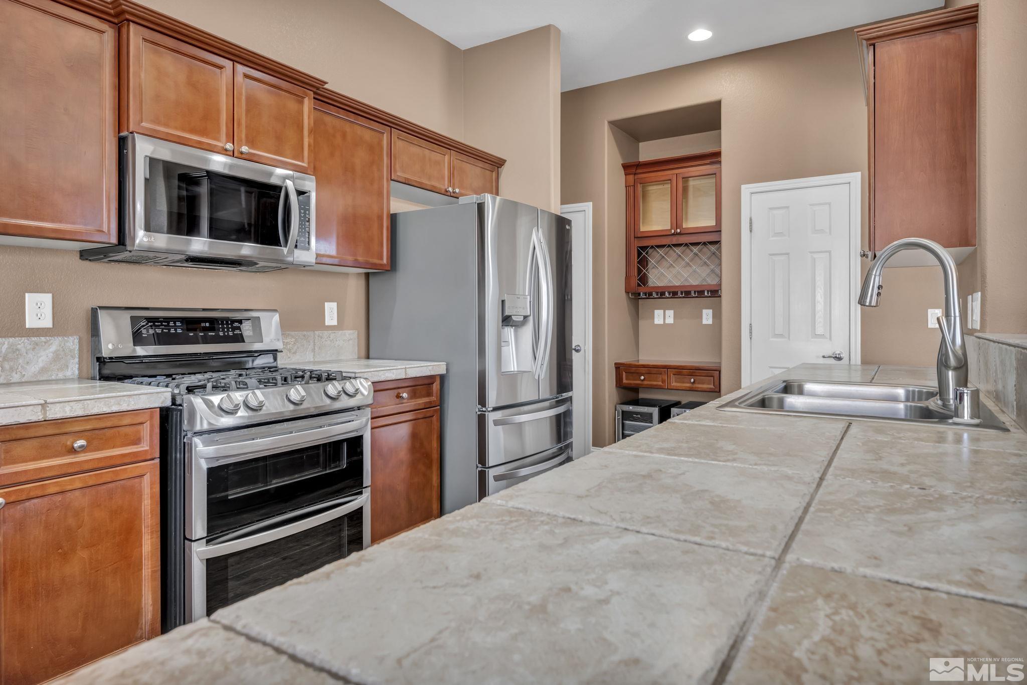 7301 Lacerta Drive Sparks, NV 89436 - Photo 23 of 39 a kitchen with stainless steel appliances a stove refrigerator and microwave