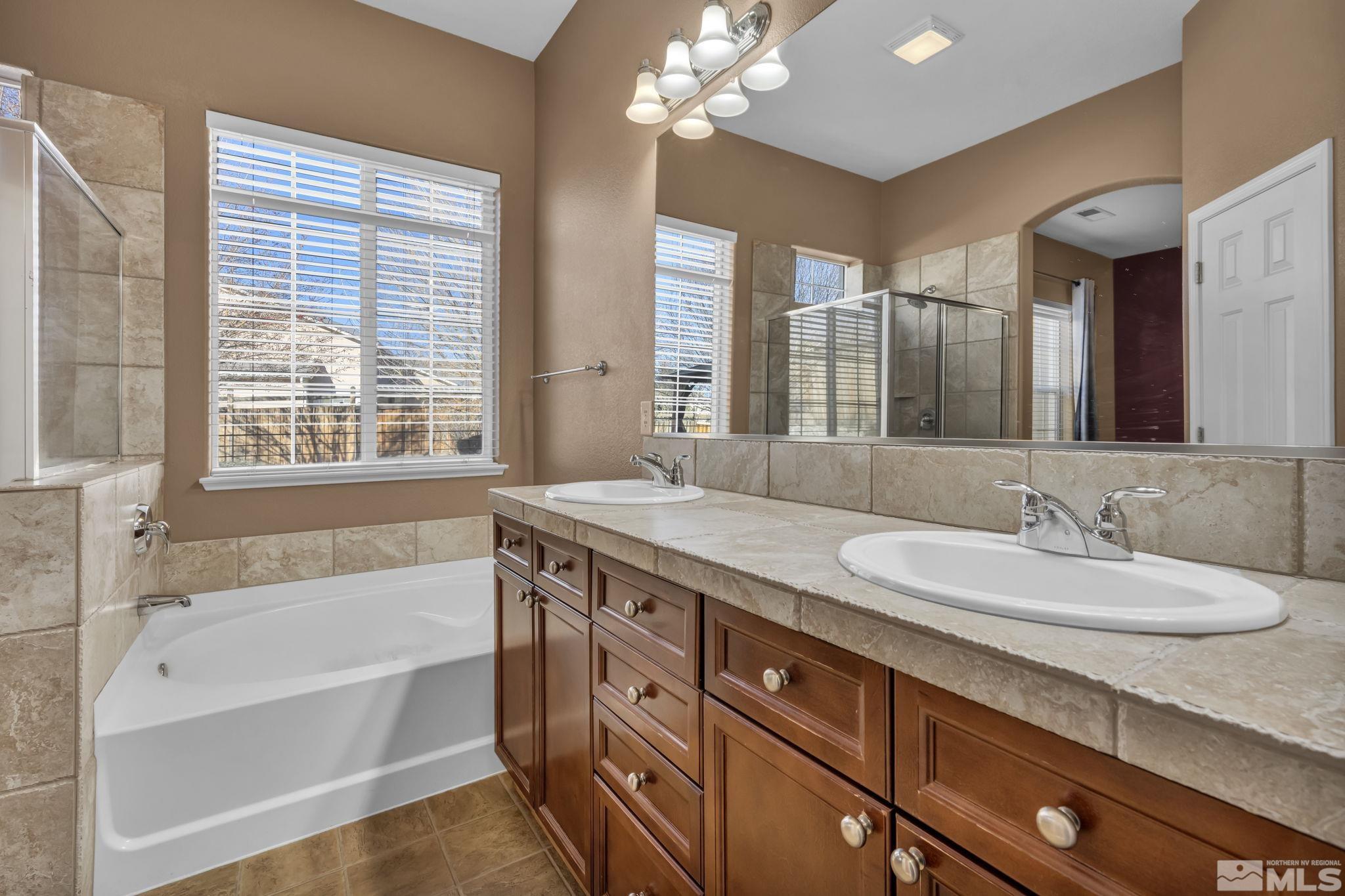 7301 Lacerta Drive Sparks, NV 89436 - Photo 27 of 39 a bathroom with a granite countertop sink mirror and a bathtub